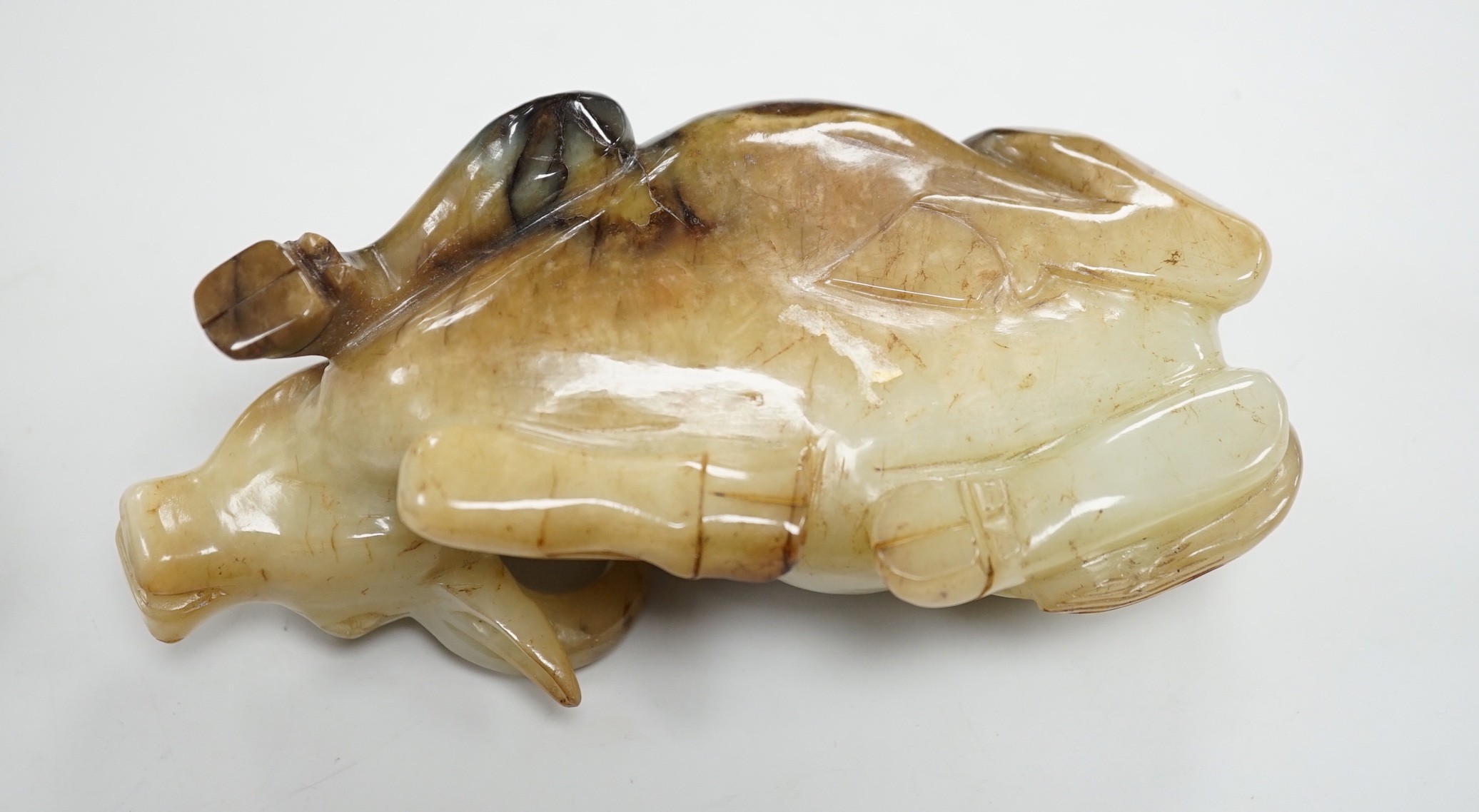 A large Chinese grey and black jade figure of a recumbent buffalo, 17cm long, wood stand